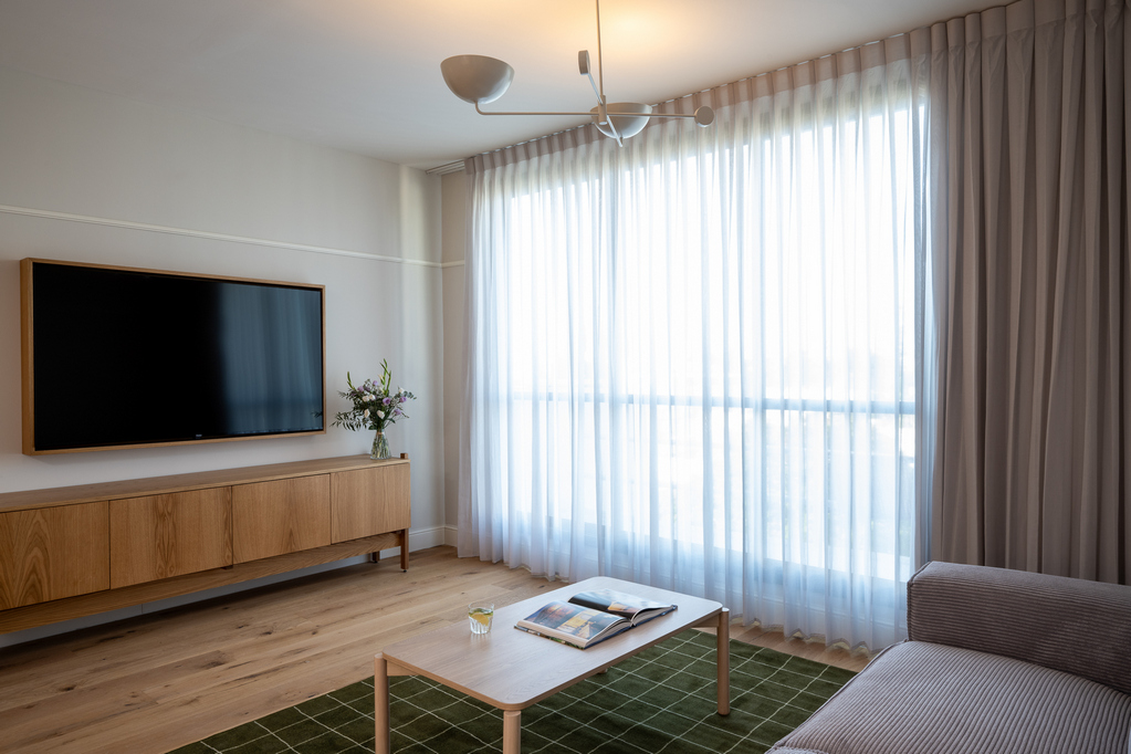 Bright and inviting living space in the One-Bedroom at master Mazeh Tel Aviv, designed for comfort with contemporary furnishings.