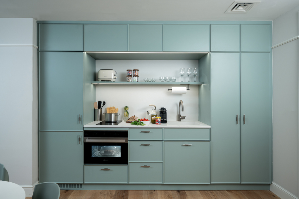 Well-equipped kitchen in the One-Bedroom at master Mazeh Tel Aviv, featuring modern appliances and sleek cabinetry.
