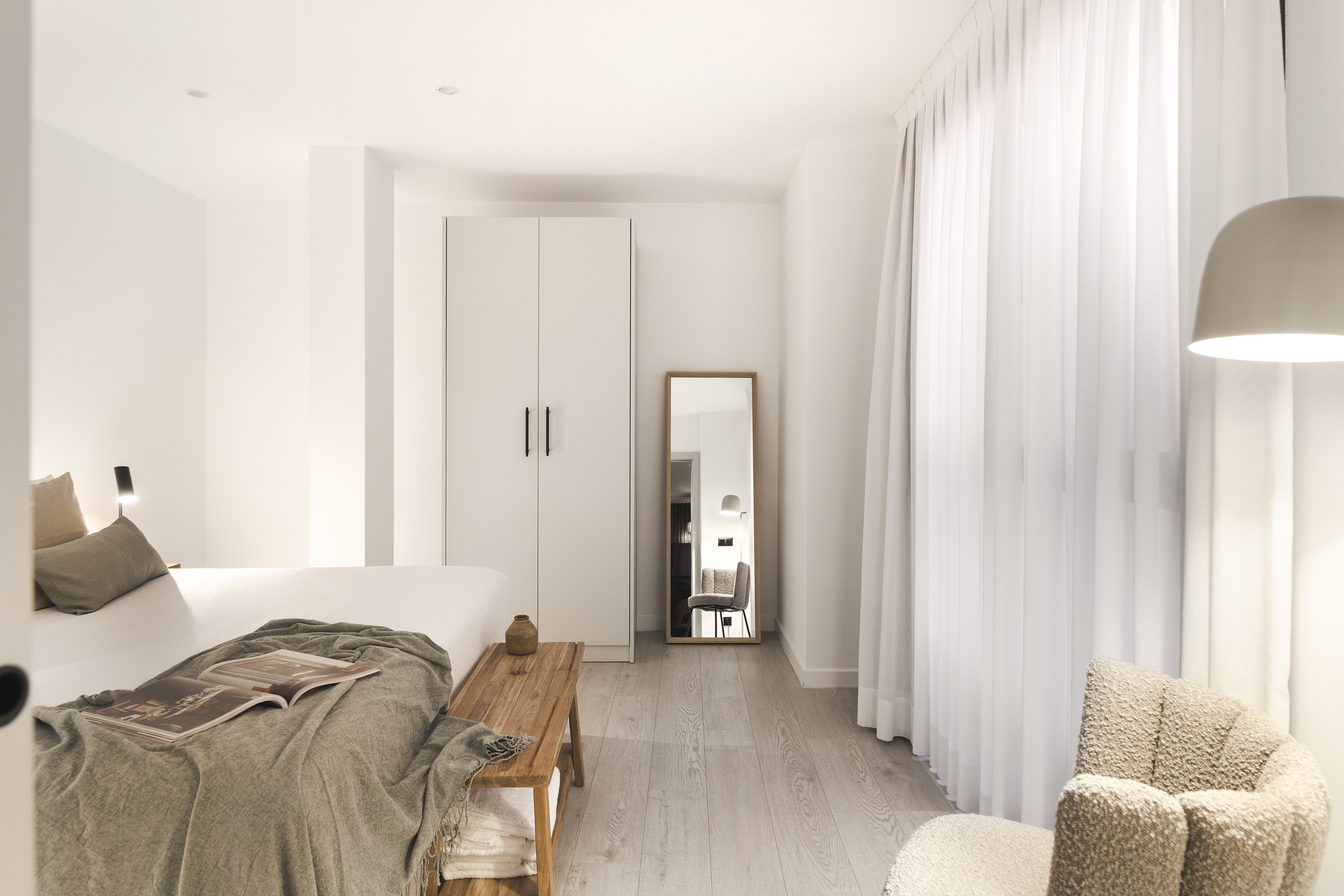Interior One Bedroom Apartment at master La Rambla Barcelona with double bed, wardrobe, full-length mirror, and natural light.