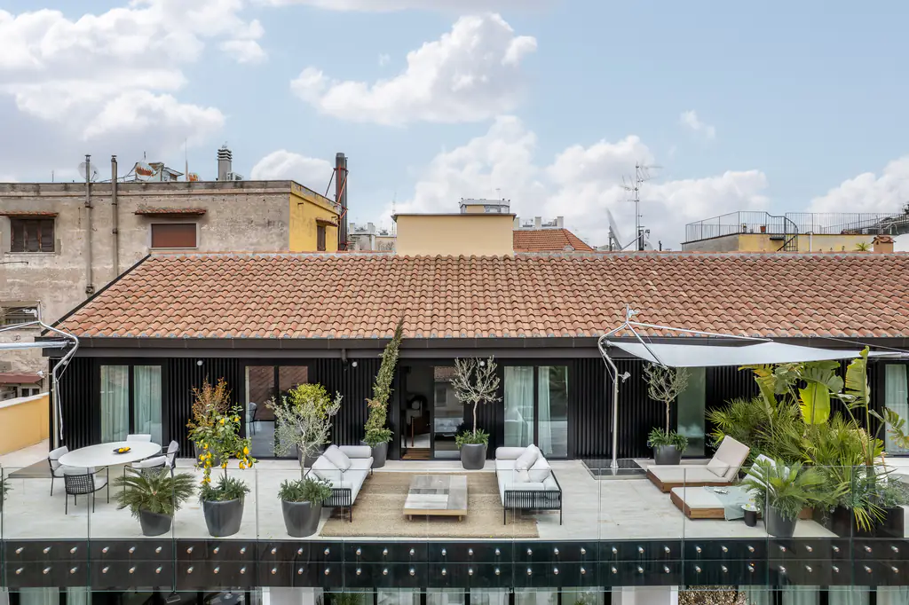 Spacious penthouse terrace at master Trevi Rome Aparthotel with outdoor seating and panoramic rooftop views.