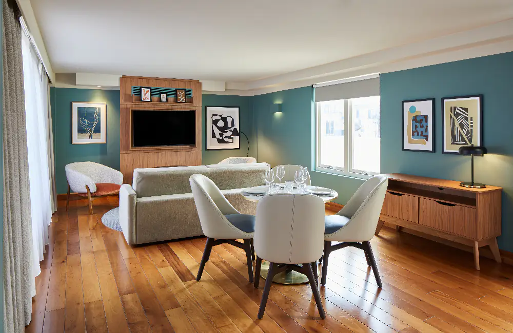 Spacious living room at master Farringdon London serviced apartments, with a comfortable sofa, round dining table, stylish decor, and large windows creating a bright and inviting space.