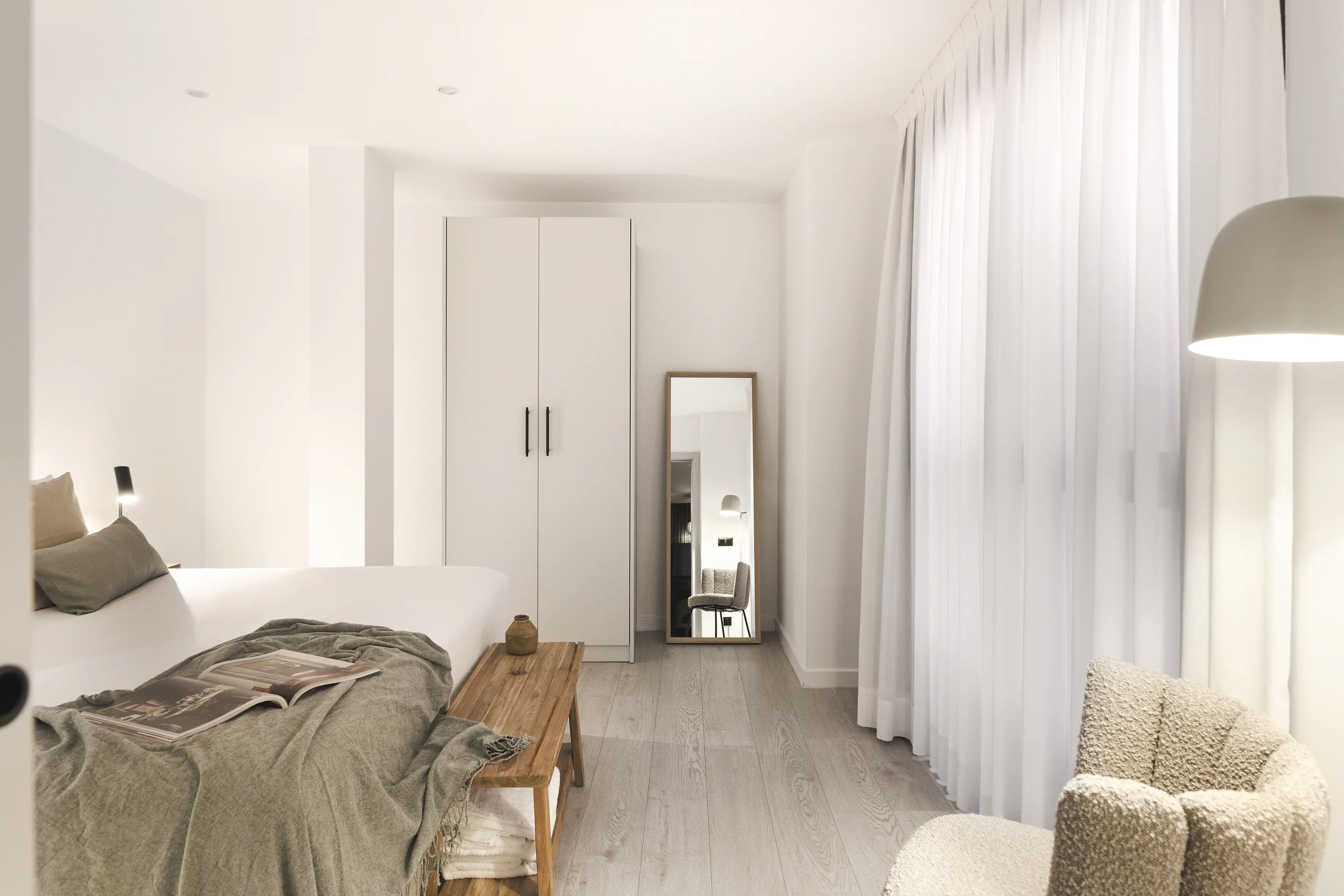 Interior One Bedroom Apartment at master La Rambla Barcelona with double bed, wardrobe, full-length mirror, and natural light.