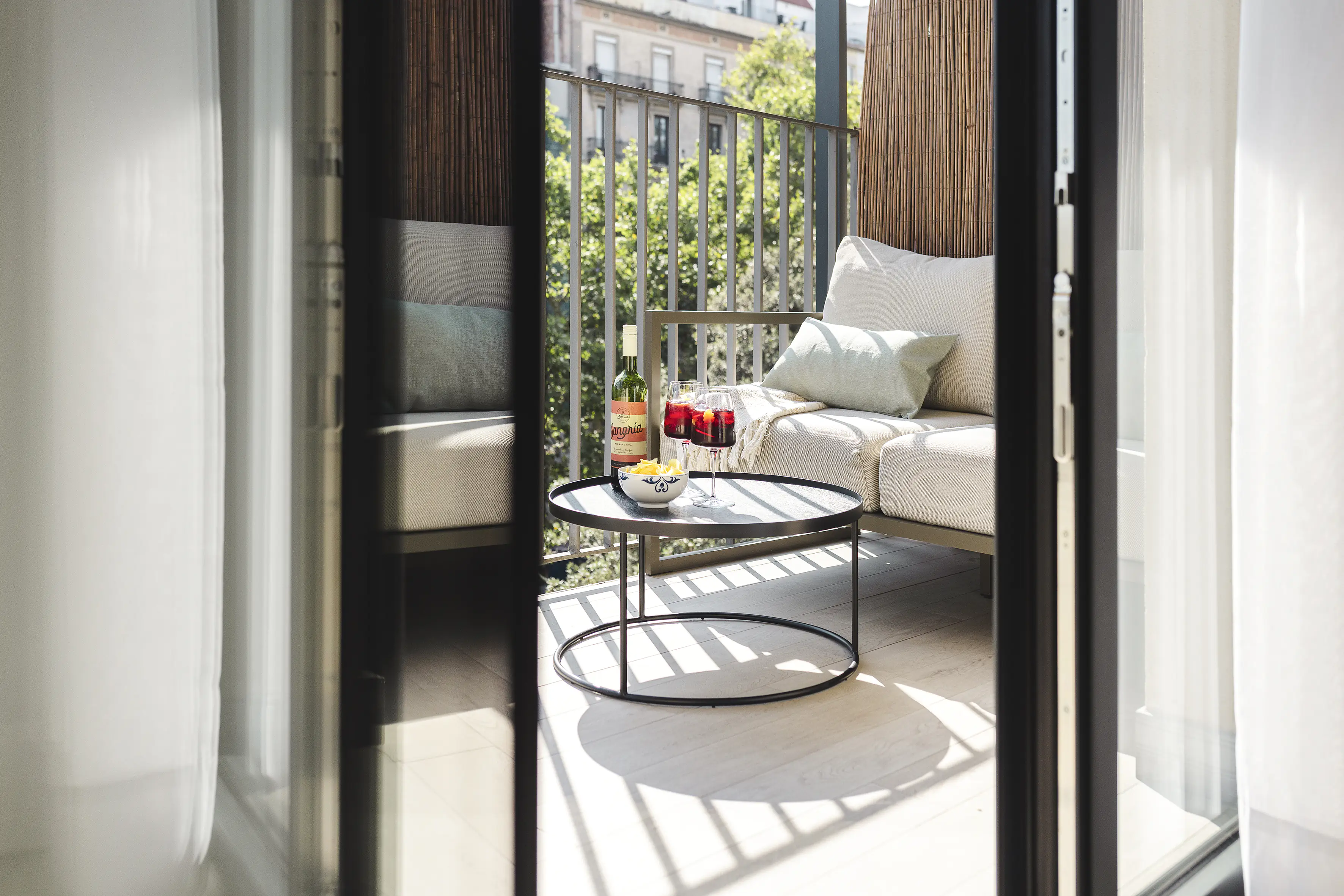 Private balcony at master La Rambla Barcelona with lounge seating, sangria glasses, and city views.